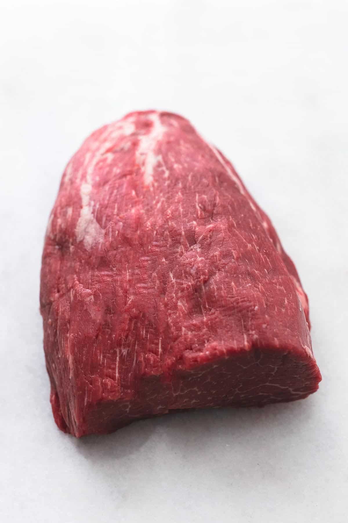 fresh beef tenderloin roast raw on marble tabletop