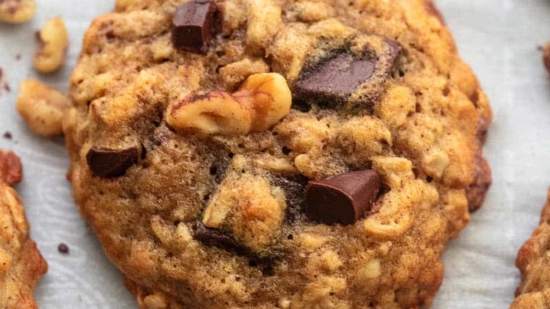 up close brown cookie with walnut pieces and chocolate chunks