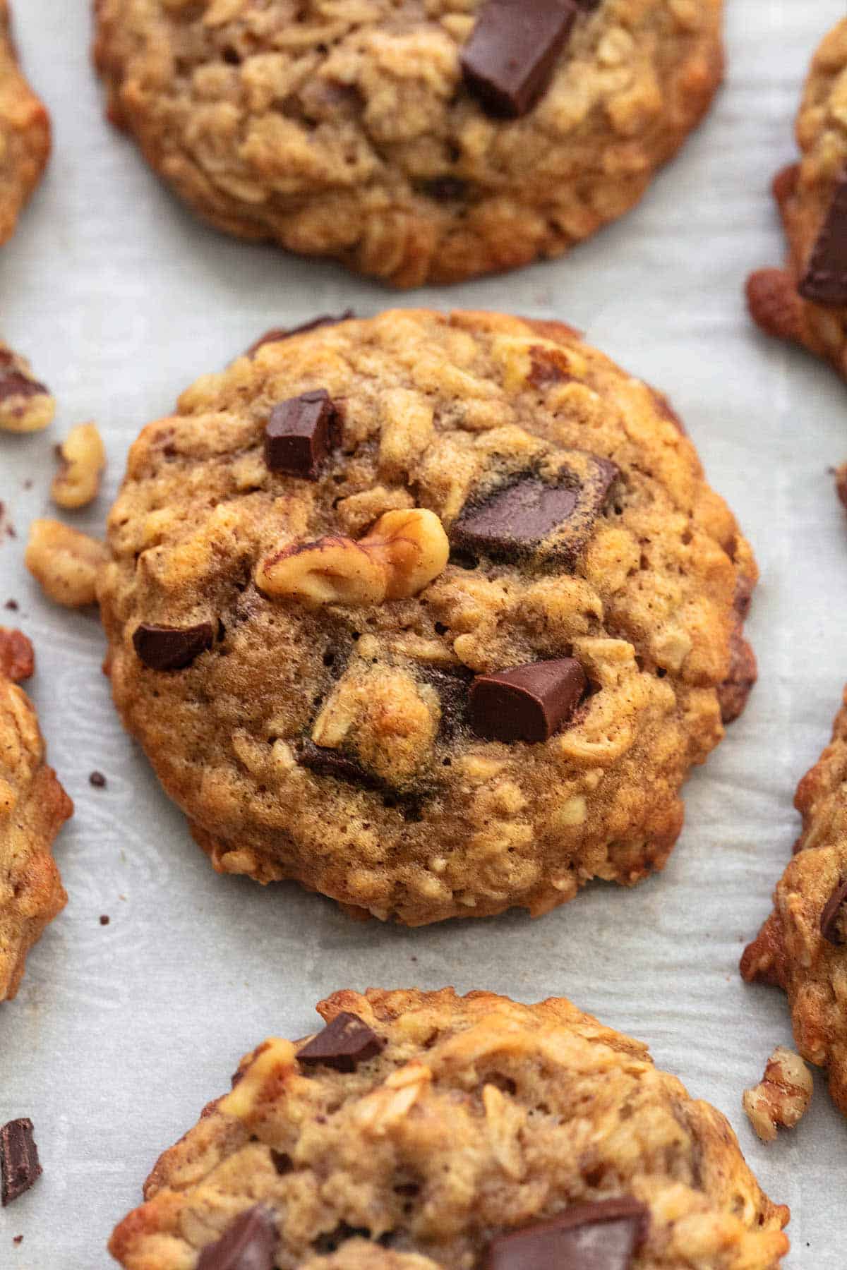 close up of a chunky monkey banana cookie with more cookies around it.