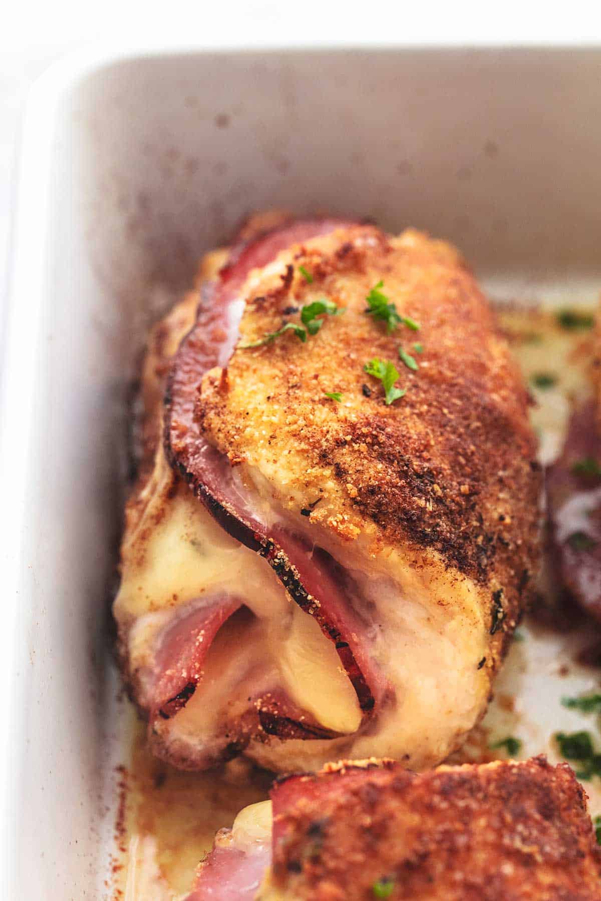 up close view of chicken, ham, and cheese bundle in white dish