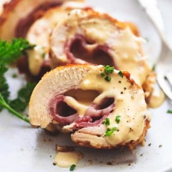 sliced chicken cordon bleu with creamy sauce on a plate