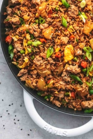 up close quarter of a cast iron skillet filled with asian rice dish