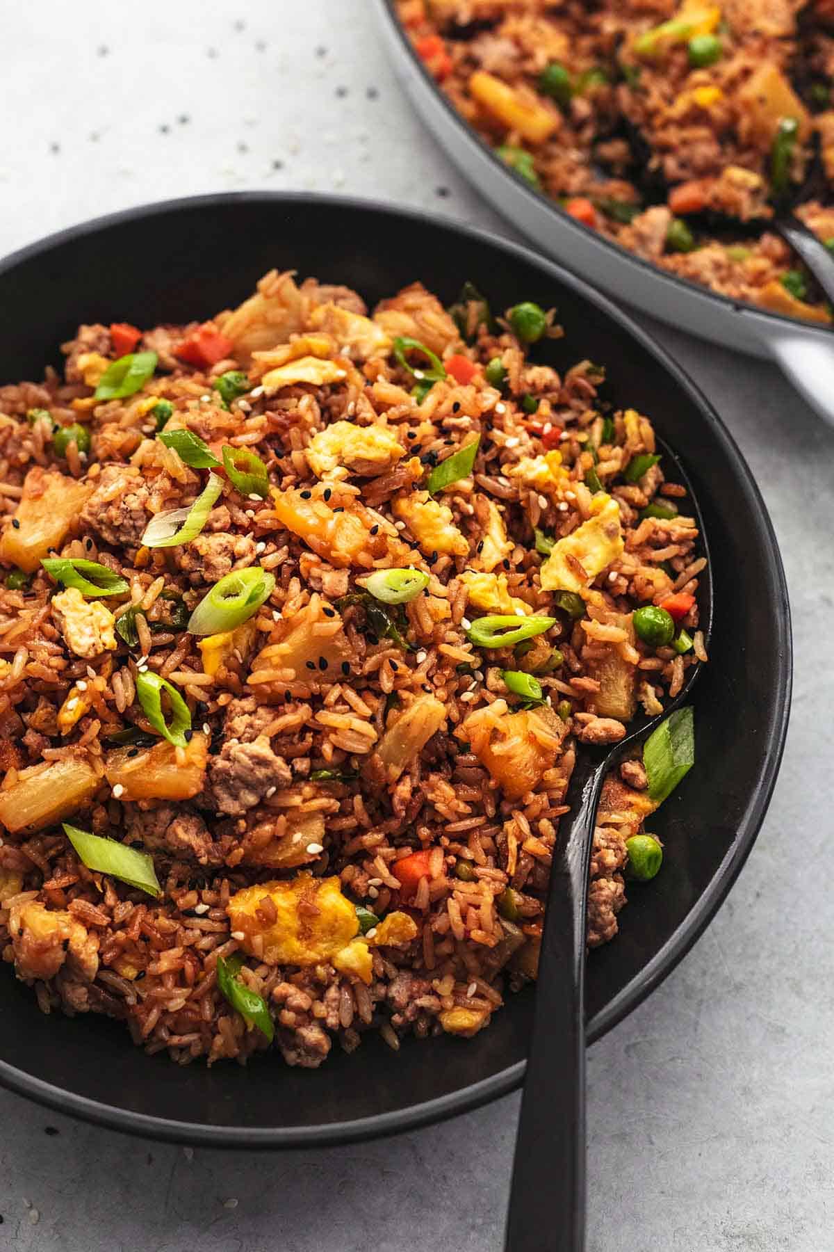 fried rice in black bowl with serving spoon