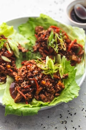 meet and veggies in brown sauce in lettuce cups on plate