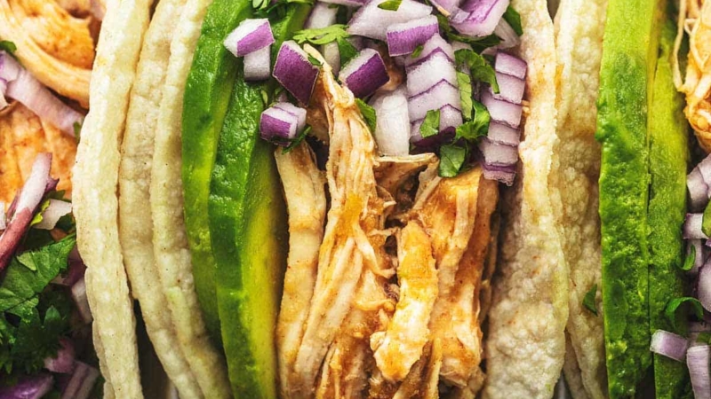 overhead view of shredded chicken tacos with onions and cilantro