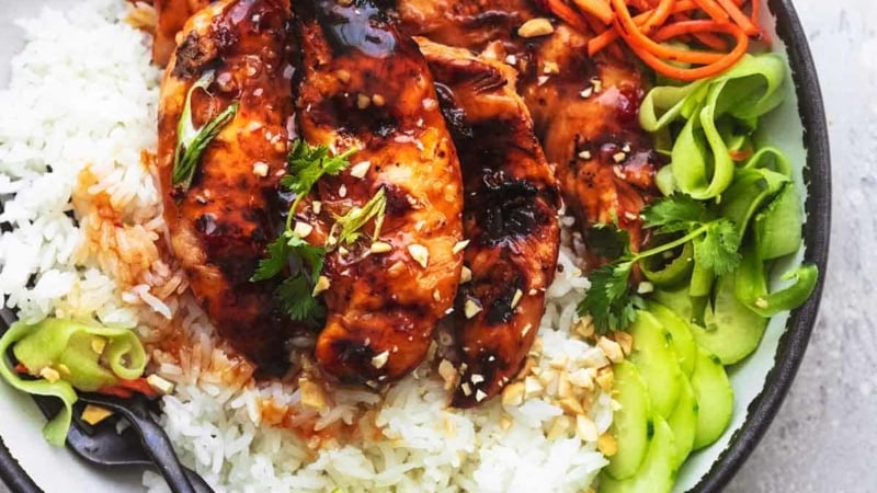 overhead view of plate with grilled chicken, julienned carrots, cucumber ribbons, and lime wedges