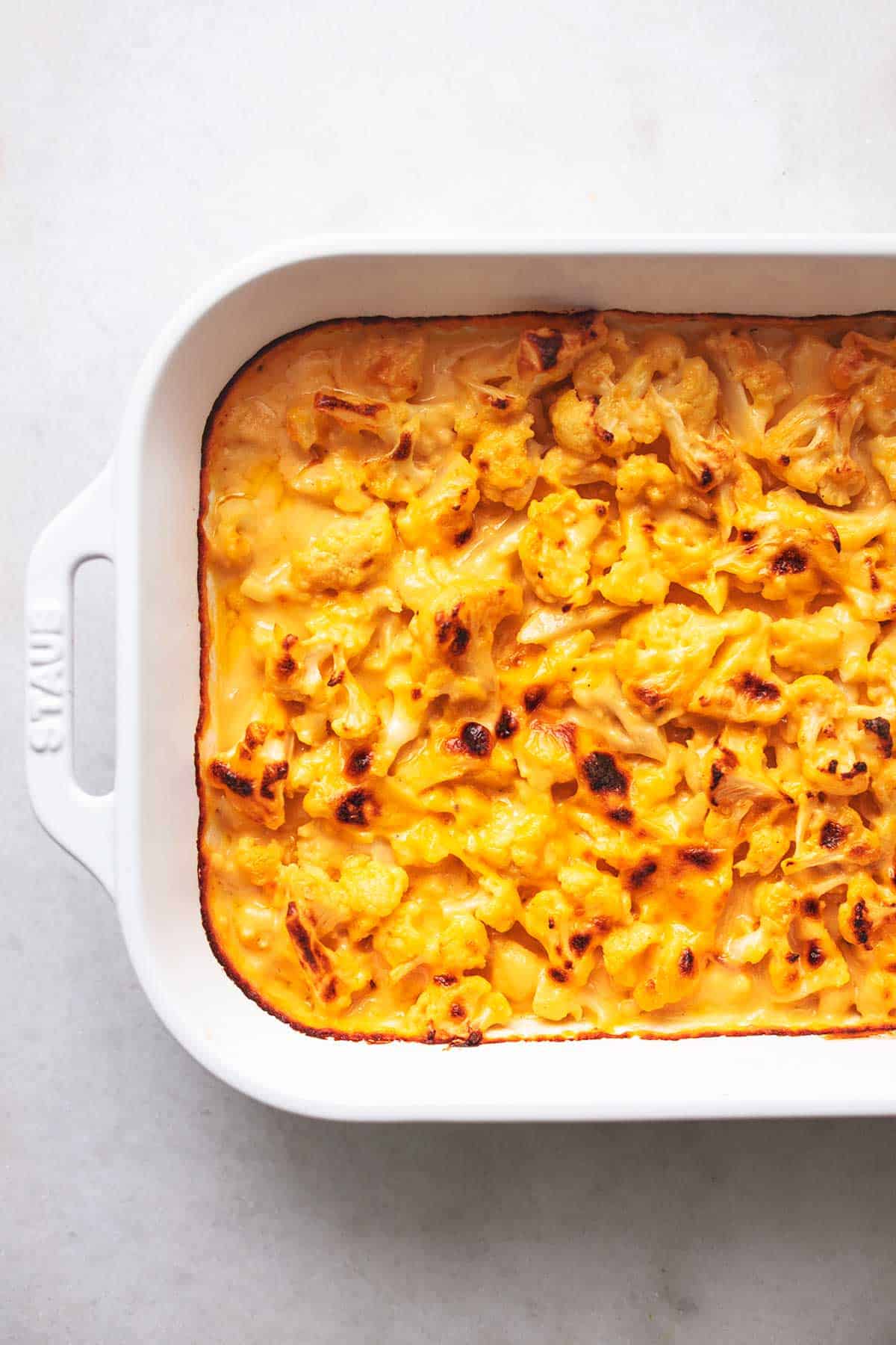 close up top view of baked cauliflower mac and cheese in a baking pan.