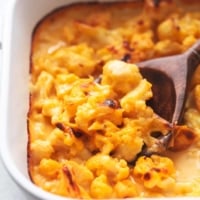 serving spoon with cauliflower mac and cheese in white pan