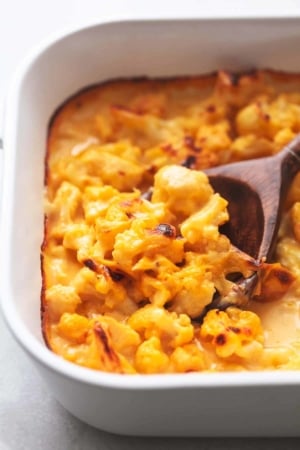 serving spoon with cauliflower mac and cheese in white pan