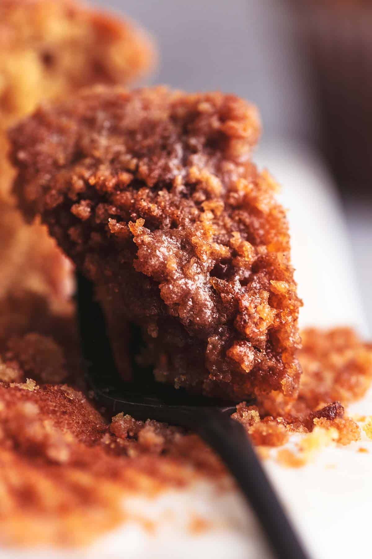 buttery streusel bite of muffin on black fork up close