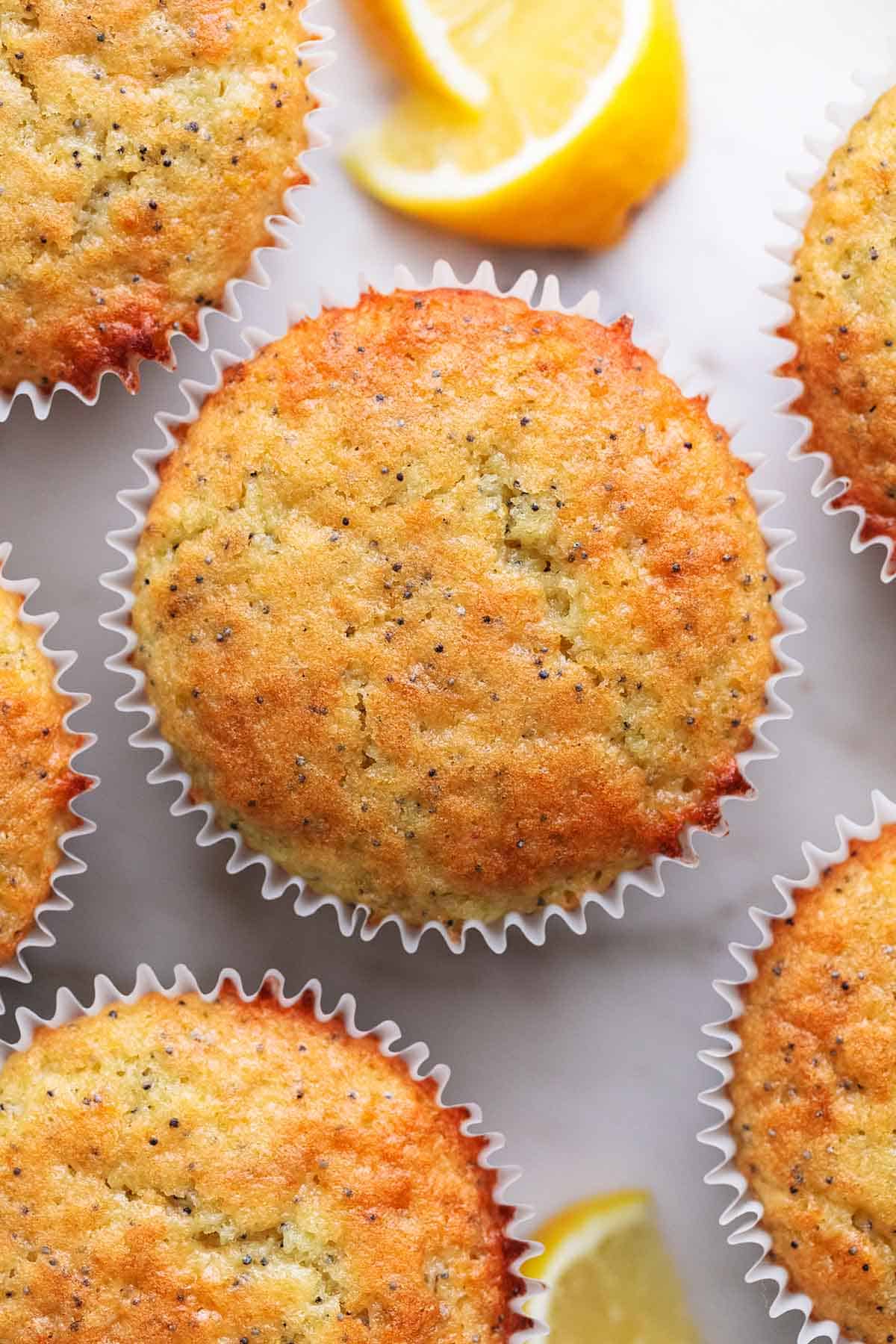 close up top view of lemon poppyseed muffins and lemon slices.