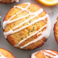 overhead view of muffins with poppy seeds, lemon wedges, and lemon glaze