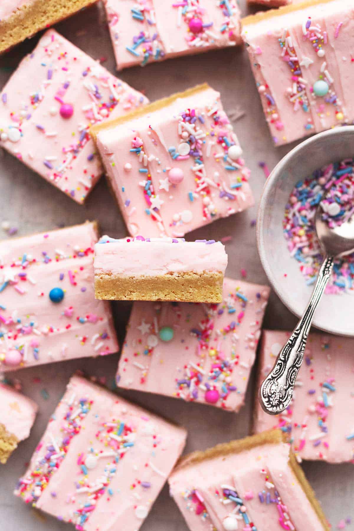 top view of sugar cookie bars with pink frosting and sprinkles.