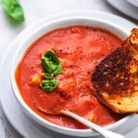 one and a quarter bowls of tomato soup with fresh basil