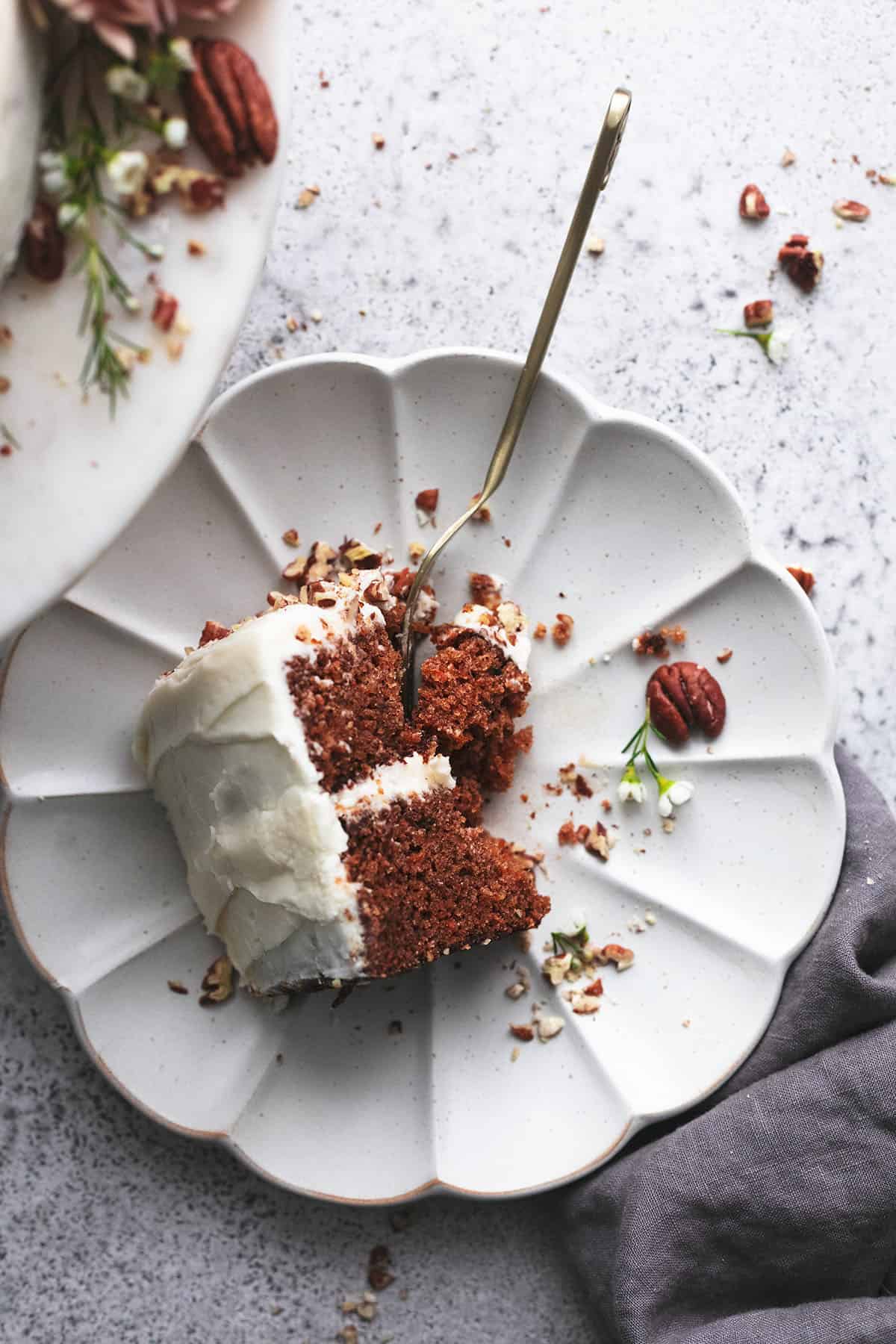 overhead view of piece of partially eaten cake on plate with napkin on side