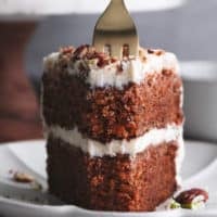 fork cutting into slice of carrot cake on a plate
