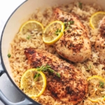 chicken with lemon slices and rice in a skillet