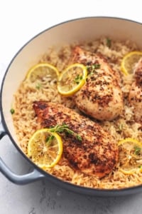 chicken with lemon slices and rice in a skillet