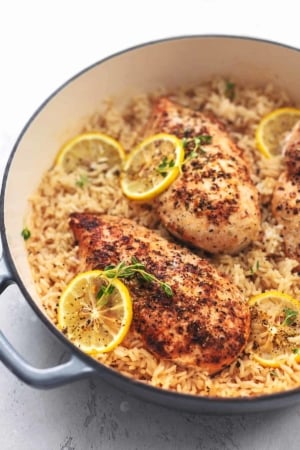 chicken with lemon slices and rice in a skillet