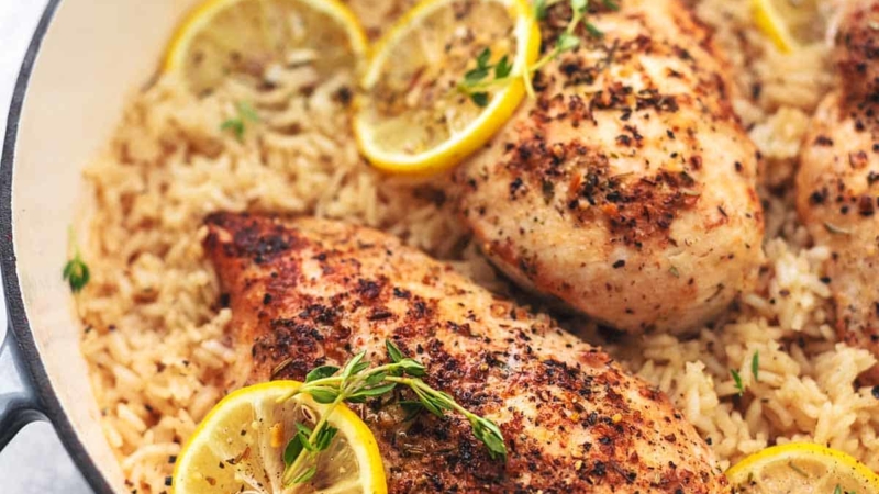 chicken with lemon slices and rice in a skillet