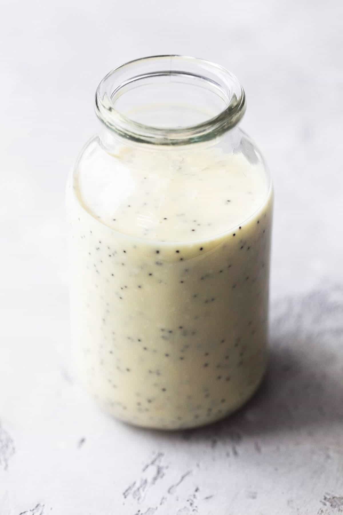 creamy poppy seed dressing in clear glass jar