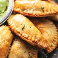 up close baked empanadas piled on a plate