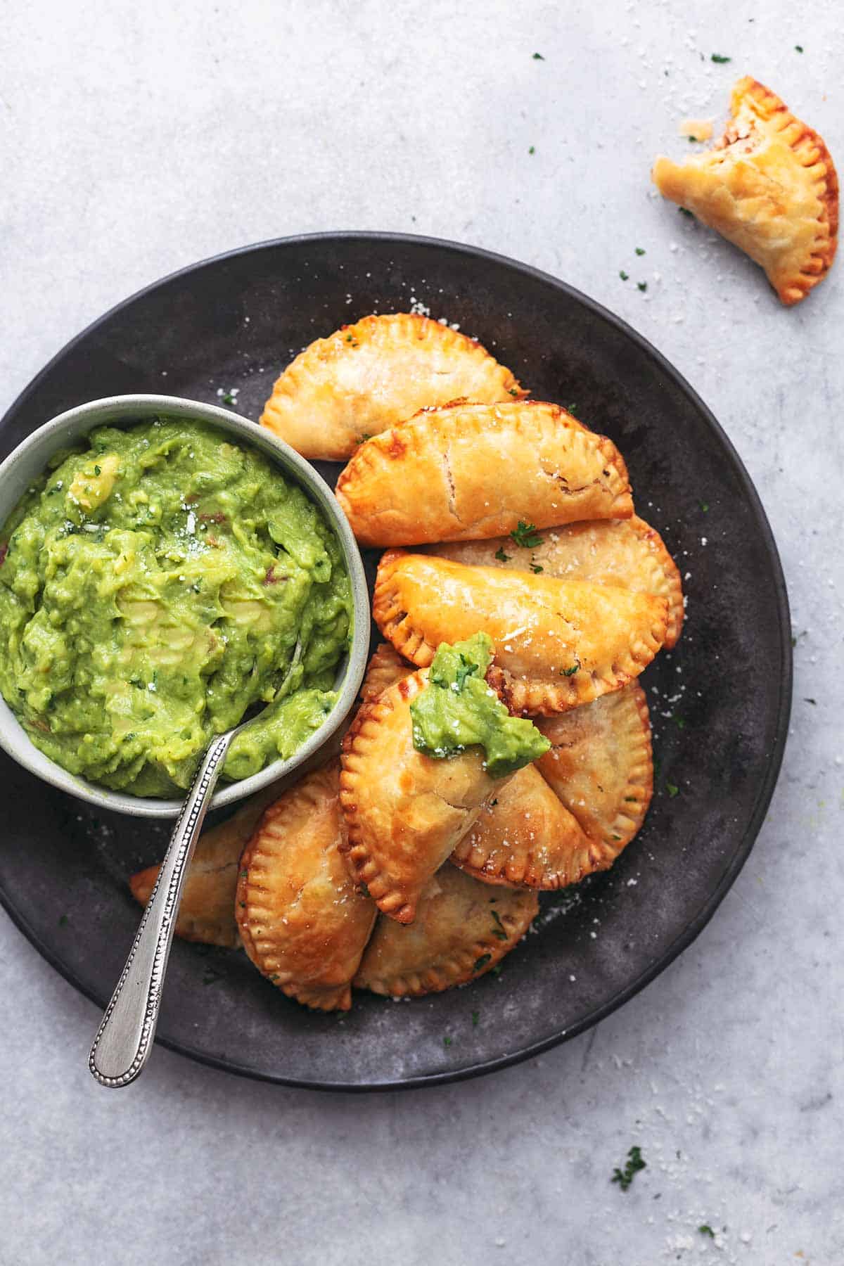 overhead view of empanadas and guacamole on plate