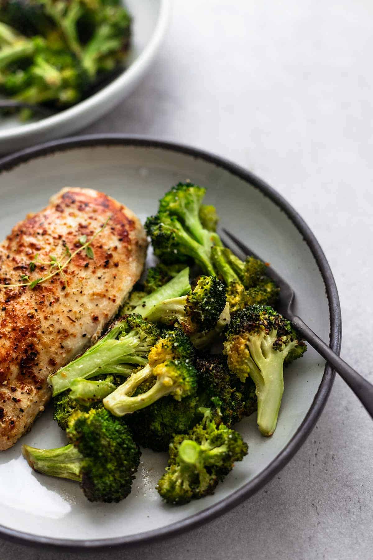 close up of chicken and broccoli skillet with fork on a plate.