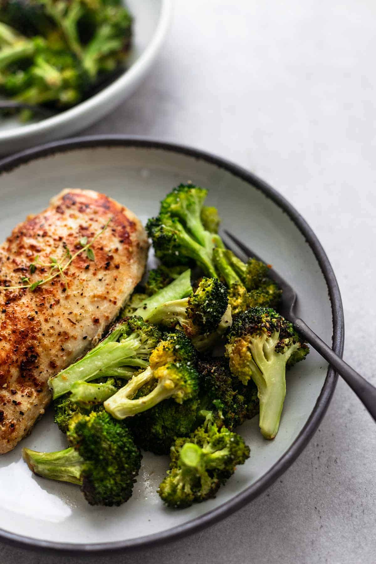 close up view of sauteed broccoli florets with fork on one half of plate