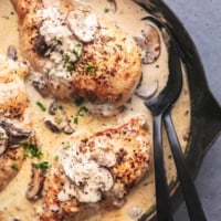 overhead view of half of a skillet with chicken breasts with creamy brown sauce