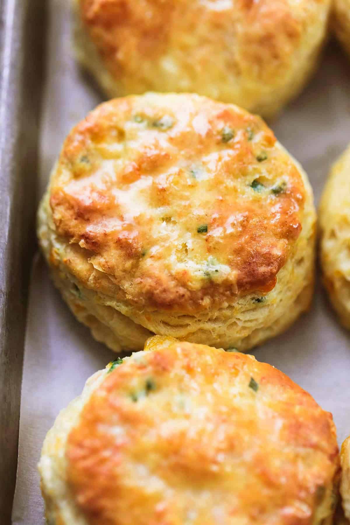 close up of buttermilk biscuits on a baking sheet.