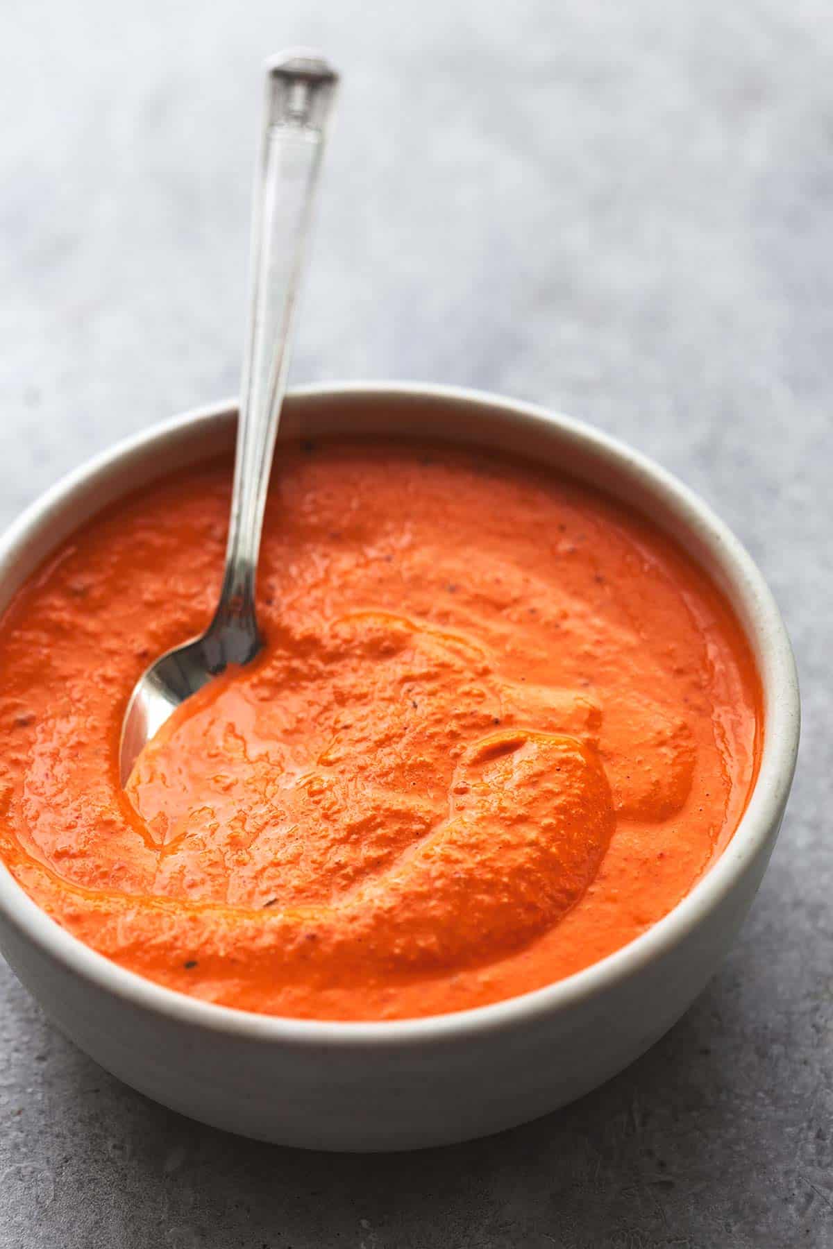 roasted red pepper sauce with a spoon in a bowl.