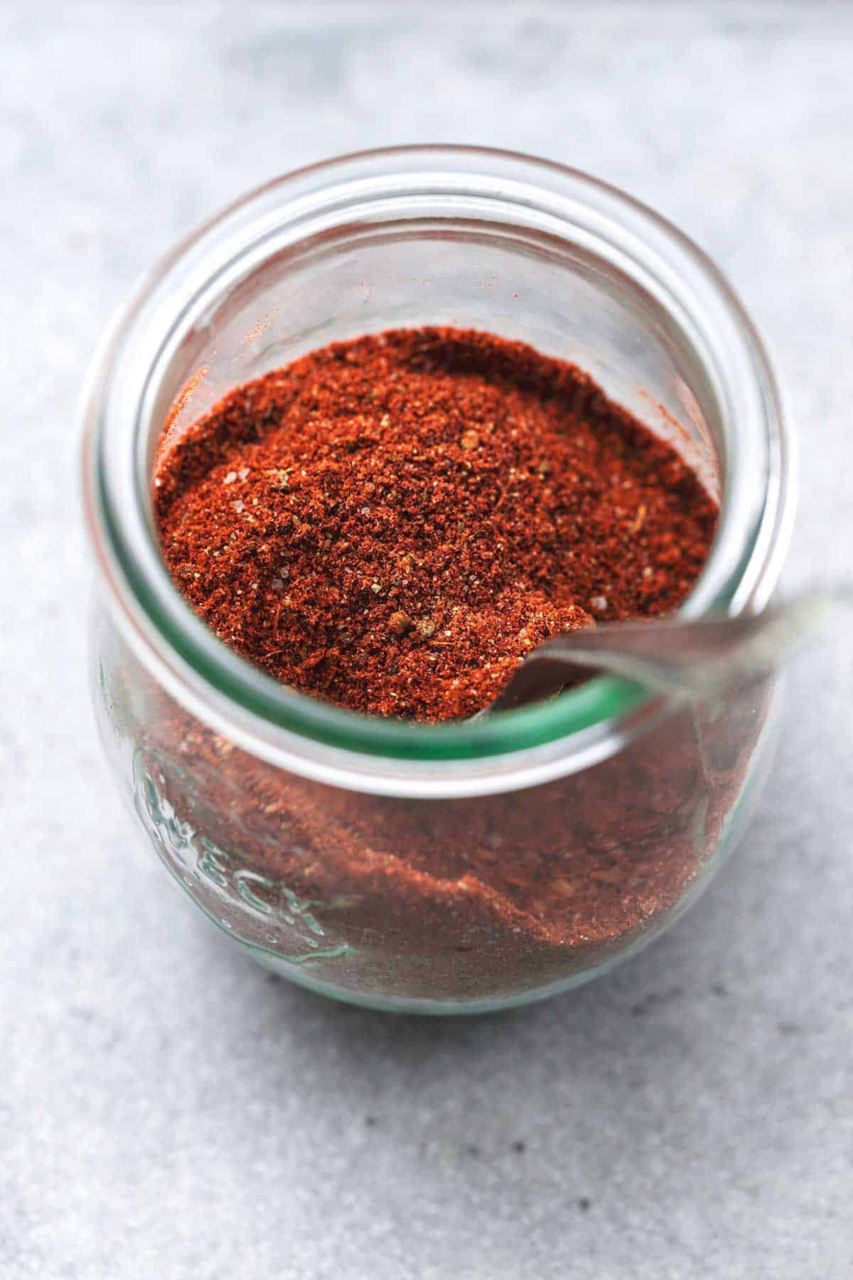 seasoning in a jar with a spoon on a table