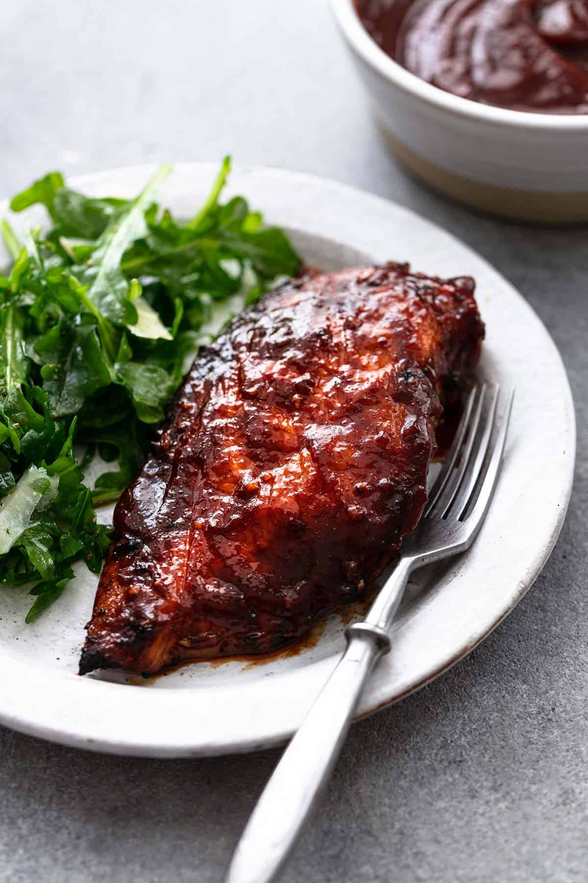 bbq chicken on plate with fork and greens