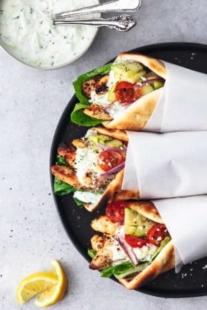 overhead view of three pita wraps filled with chicken, vegetables, and sauce