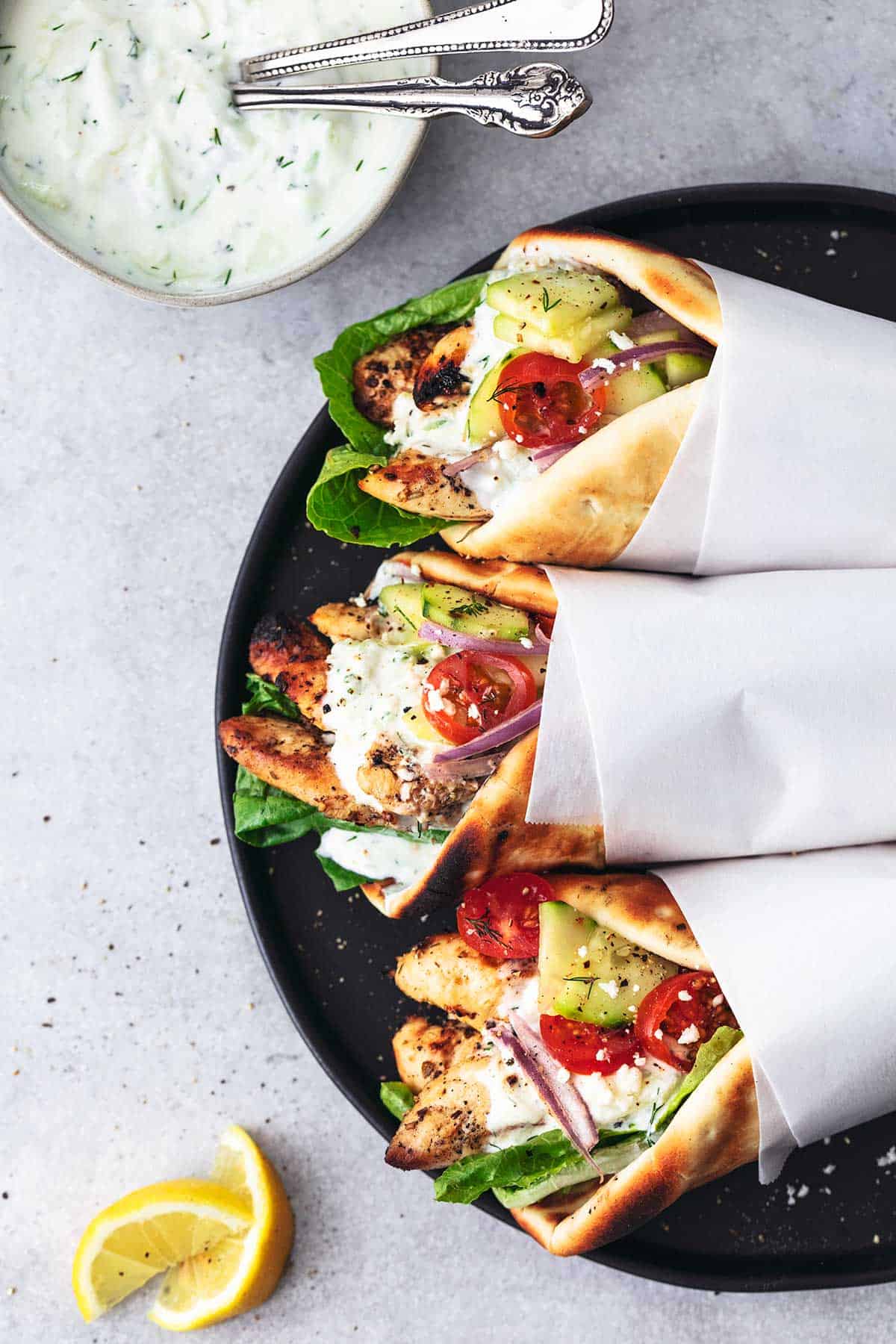 overhead view of three pita wraps filled with chicken, vegetables, and sauce