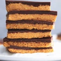 stack of peanut butter bars on top of cupcake liner on top of plate