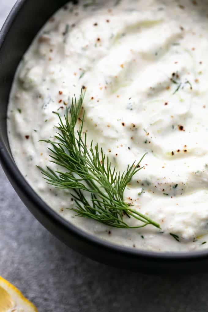dill on top of tzatziki sauce in bowl