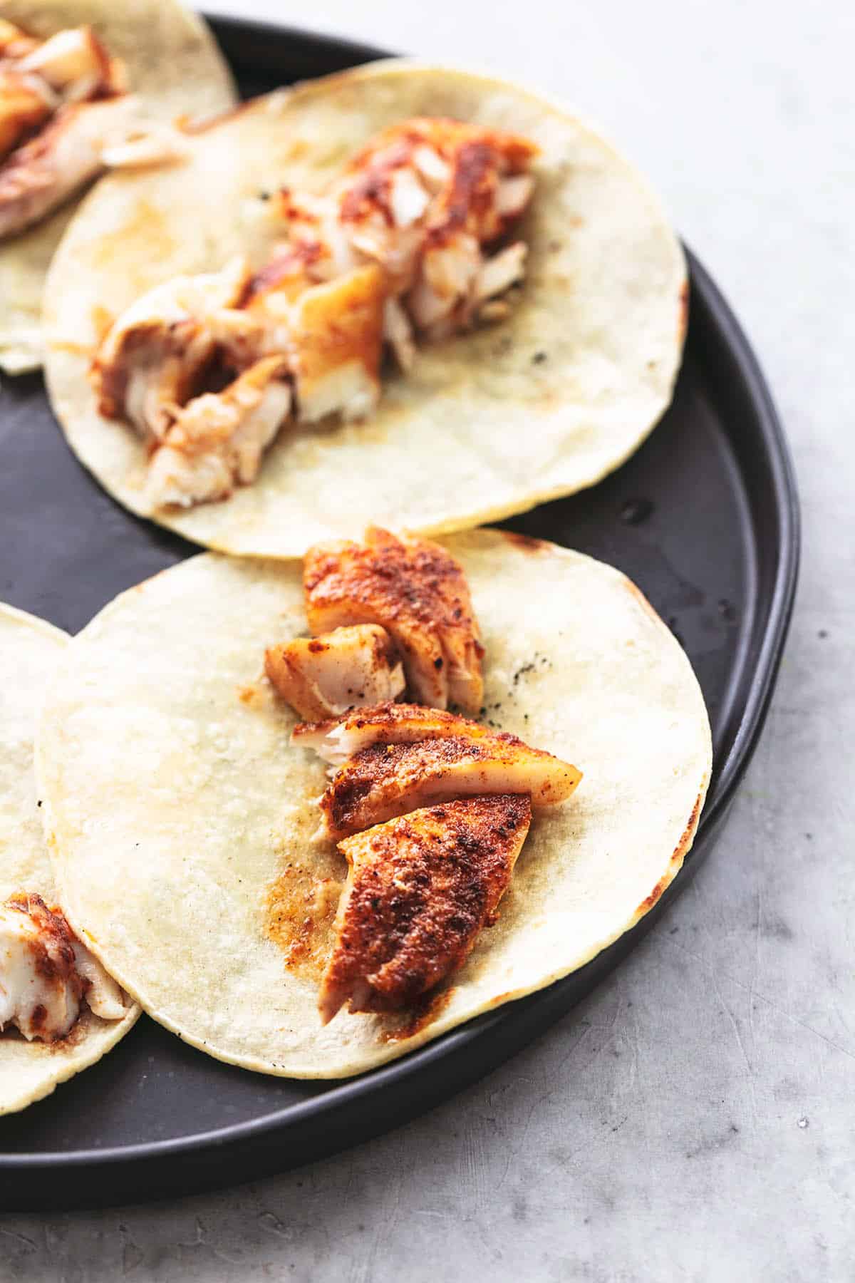 pieces of fish on tortillas on plate