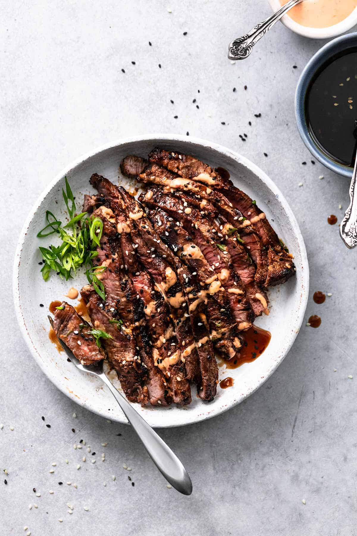 plate of grilled tri-tip steak with sauce on plate with fork