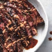 thin-sliced tri-tip steak with sauce on plate