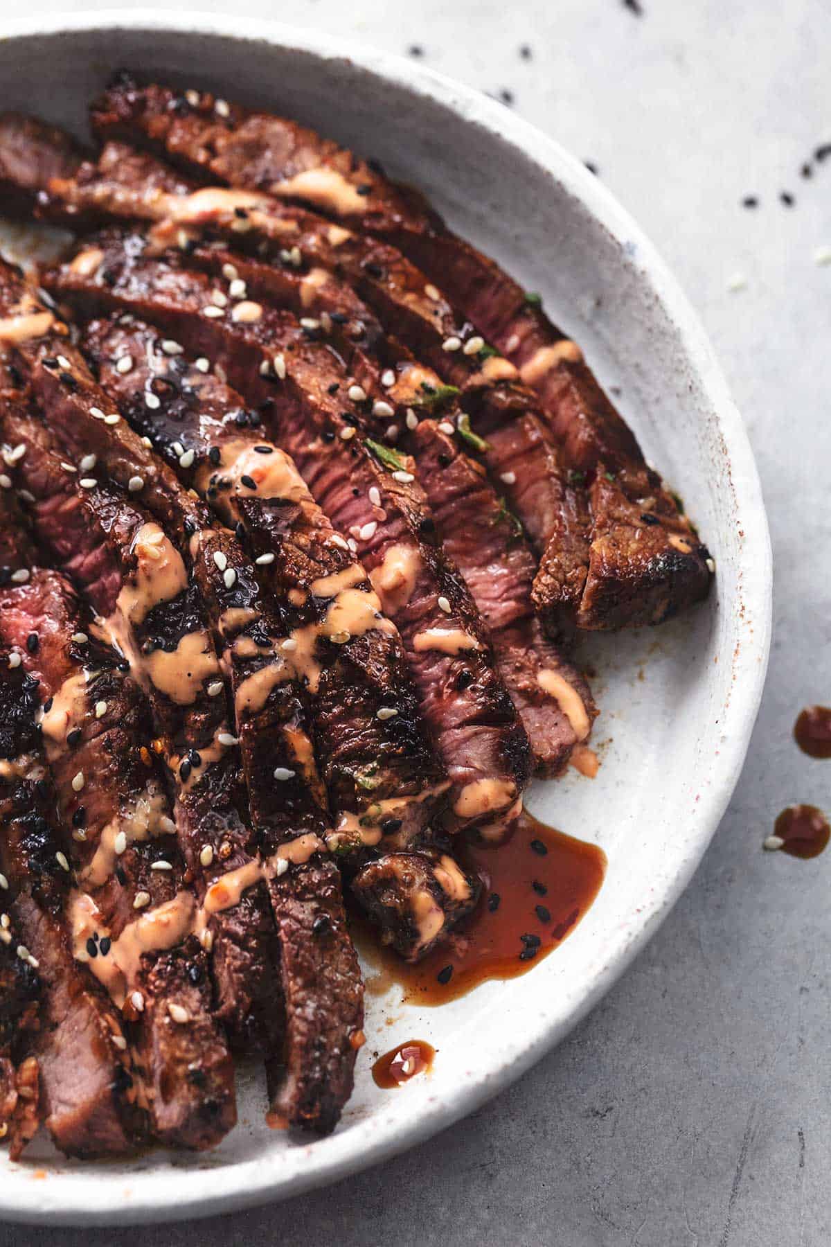 thin-sliced tri-tip steak with sauce on plate