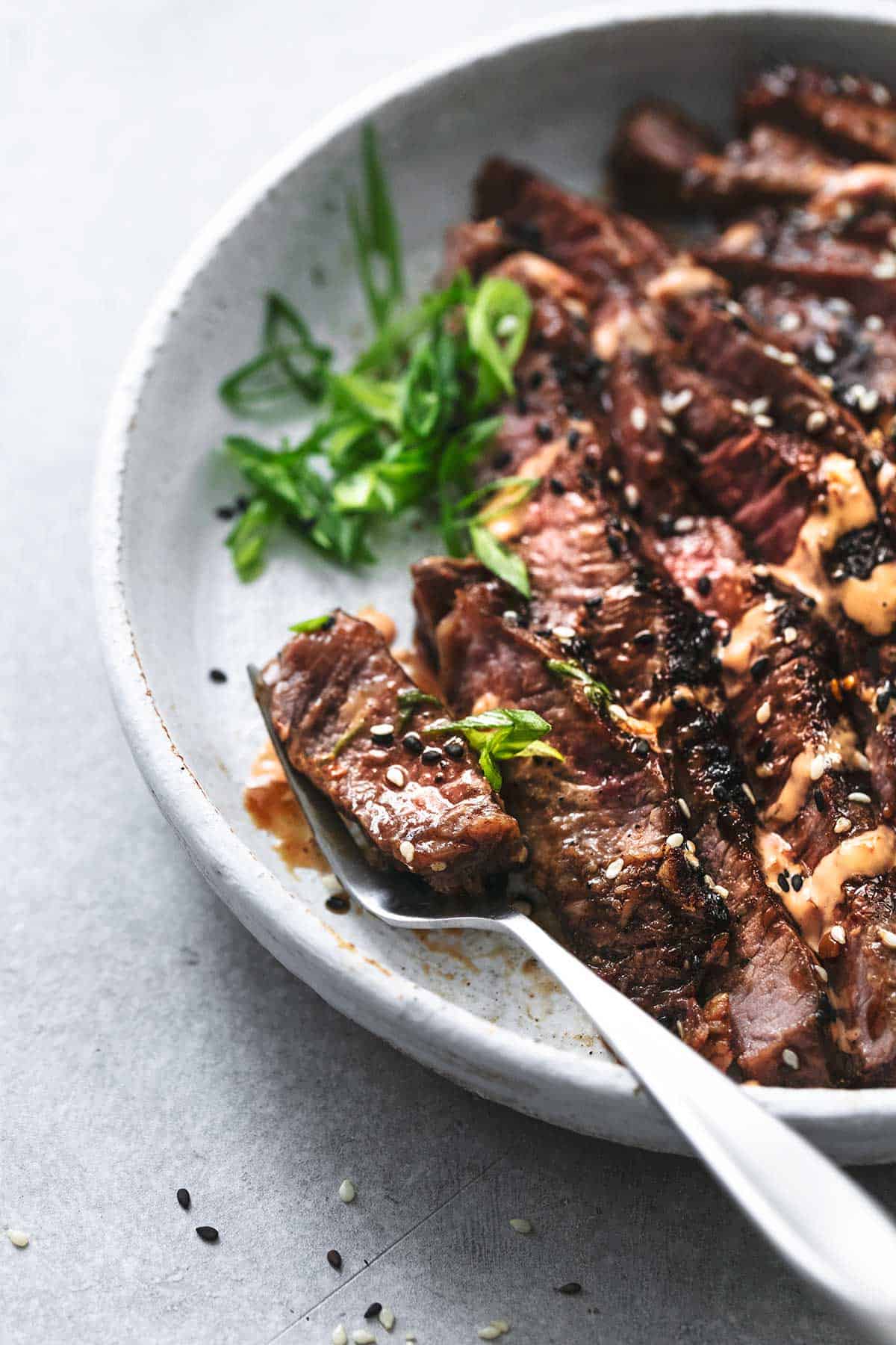 sliced beef with sauce on fork on plate