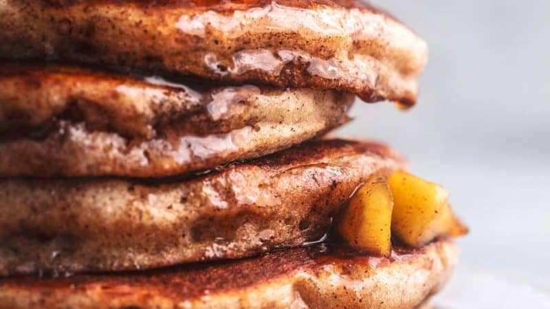 stack of apple cinnamon pancakes with apple topping and syrup