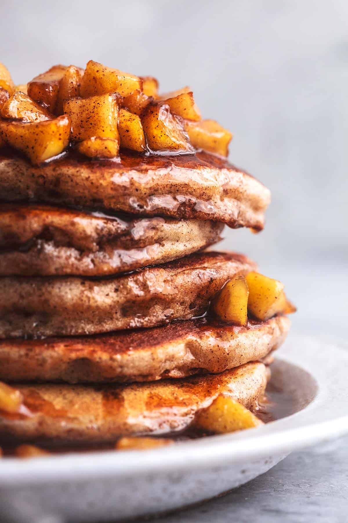 stack of apple cinnamon pancakes with apple topping and syrup