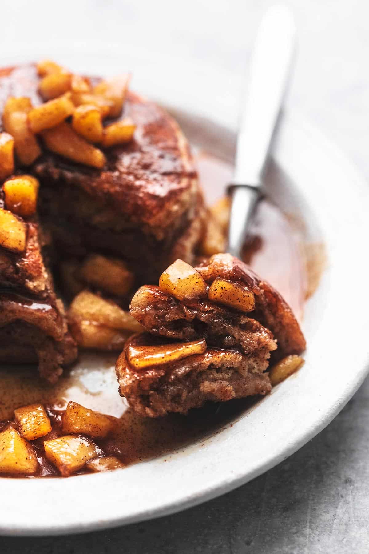 apple pancakes with syrup on plate with fork