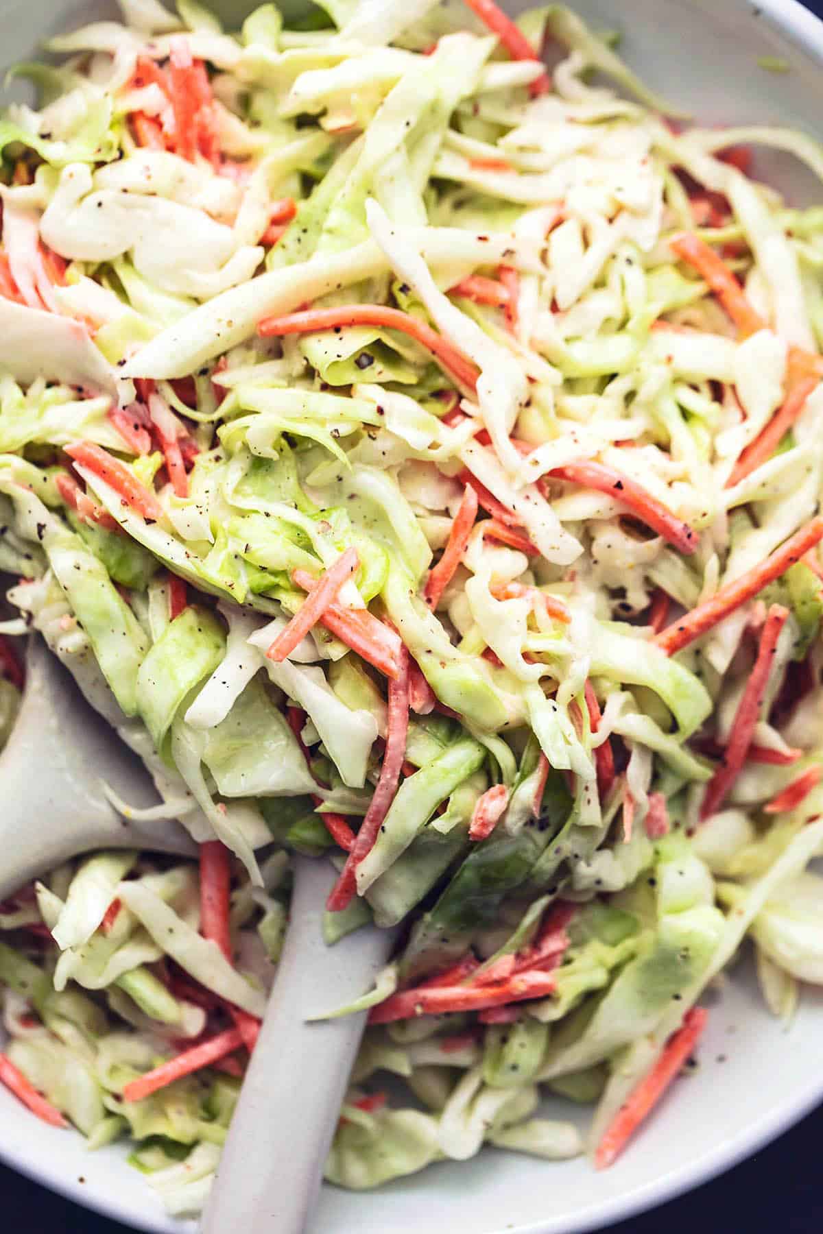 up close shredded cabbage and carrots tossed in creamy dressing