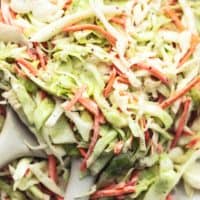 up close shredded cabbage and carrots tossed in creamy dressing