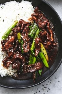 up close view of beef strips with green onions and rice topped with sesame seeds