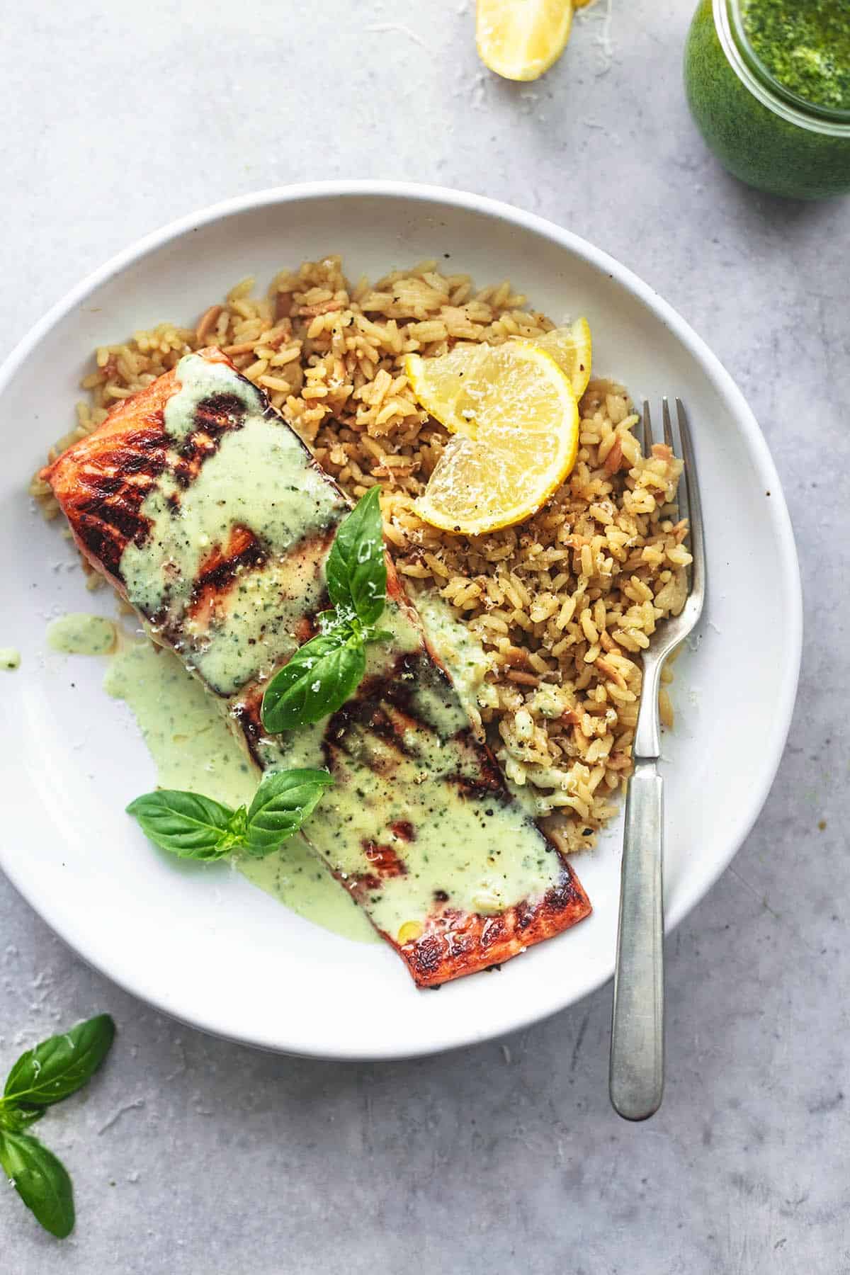 overhead view of salmon fillet with pesto sauce and orzo